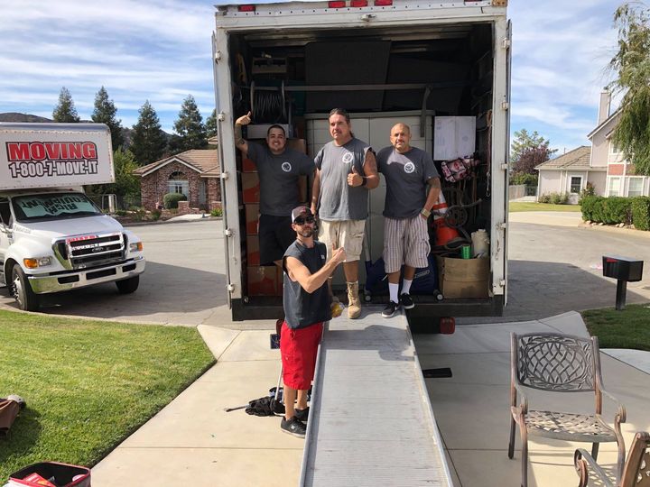 Professional Out of State movers from Patricks Moving standing on back of moving truck